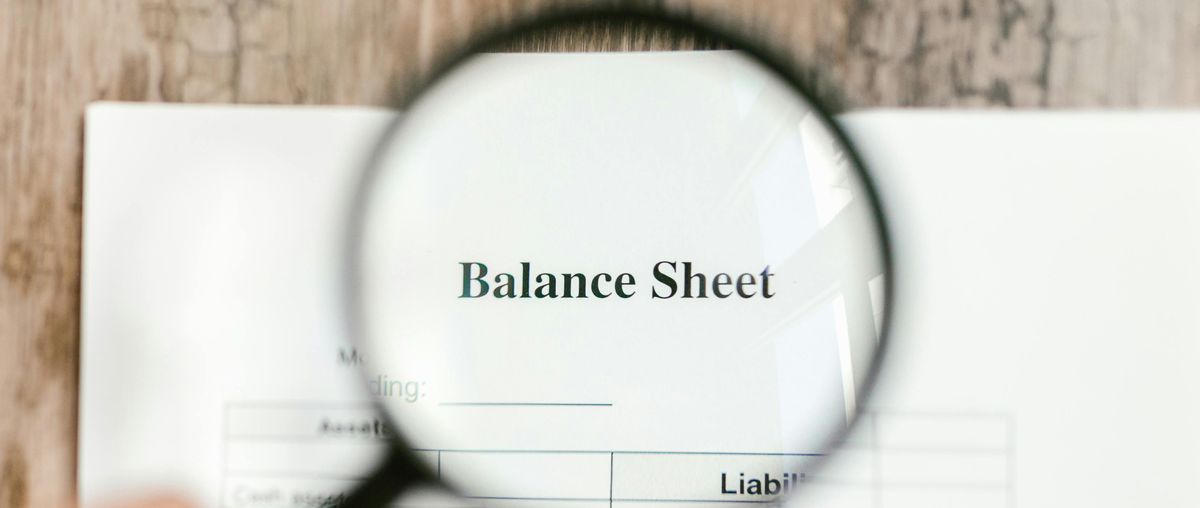 Magnifying glass over balance sheet